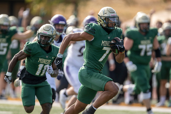 Miner football players advance the ball downfield